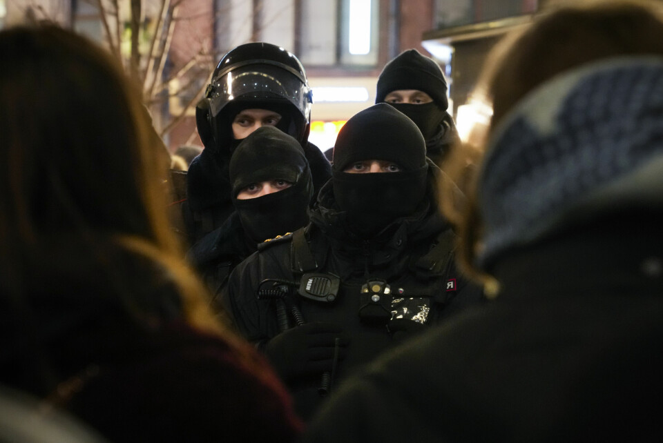 NEDSLÅENDE: Helsingforskomiteen anslår at rundt 6000 demonstranter er arrestert i Russland de siste dagene. Police officers look at demonstrators in St. Petersburg, Russia, Thursday, Feb. 24, 2022. Hundreds of people gathered in Moscow and St.Petersburg on Thursday, protesting against Russia's attack on Ukraine. Many of the demonstrators were detained. Similar protests took place in other Russian cities, and activists were also arrested. (AP Photo/Dmitri Lovetsky)