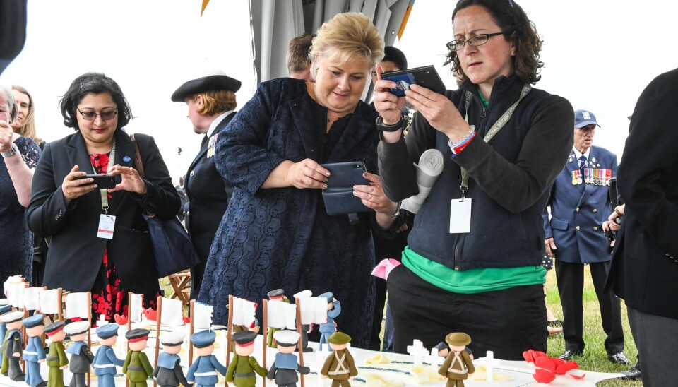 Statsminister Erna Solberg tar bilde av en spesiallagd kake som viser invasjonen av Normandie på D-dagen i 1944. Kaken ble servert under den internasjonale markeringen av 75-årsdagen for D-dagen i Portsmouth på den engelske sørkysten onsdag.