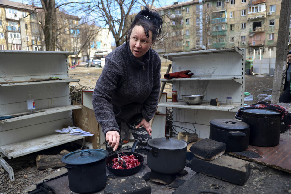 OVERTATT: En kvinne lager mat i en del av Mariupol som nå kontrolleres av Russland og russisk-støttede separatister. En kvinne lager mat i en del av Mariupol som nå kontrolleres av Russland og russisk-støttede separatister. Foto: Aleksej Aleksandrov / AP / NTB