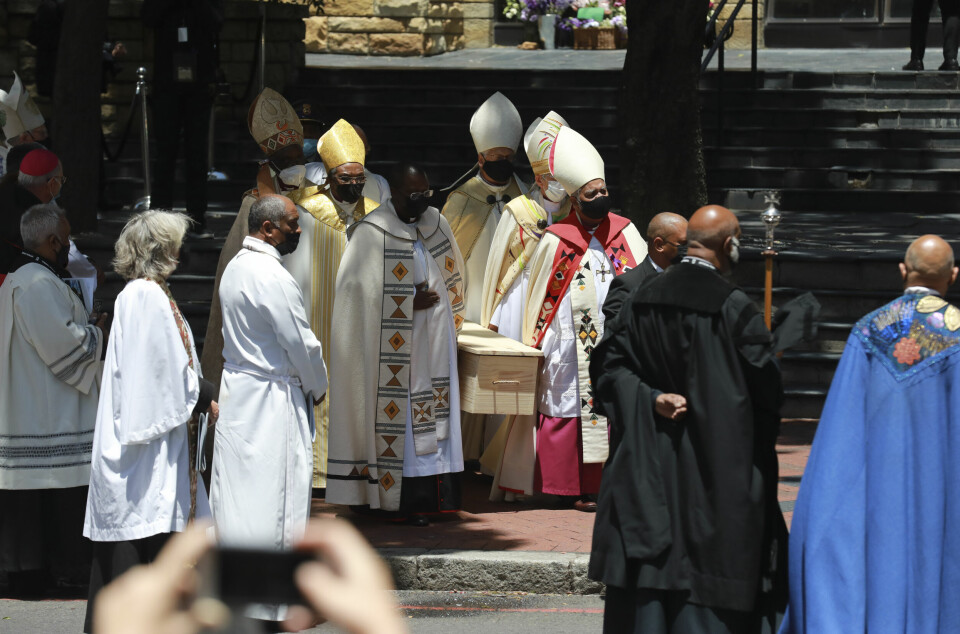 BISATT: Desmond Tutus kiste bæres ut av St.George-katedralen første nyttårsdag. Den enkle furukisten med Desmond Tutu ble båret ut av katedralen i Cape Town etter bisettelsen lørdag. Foto: Nardus Engelbrecht / AP / NTB