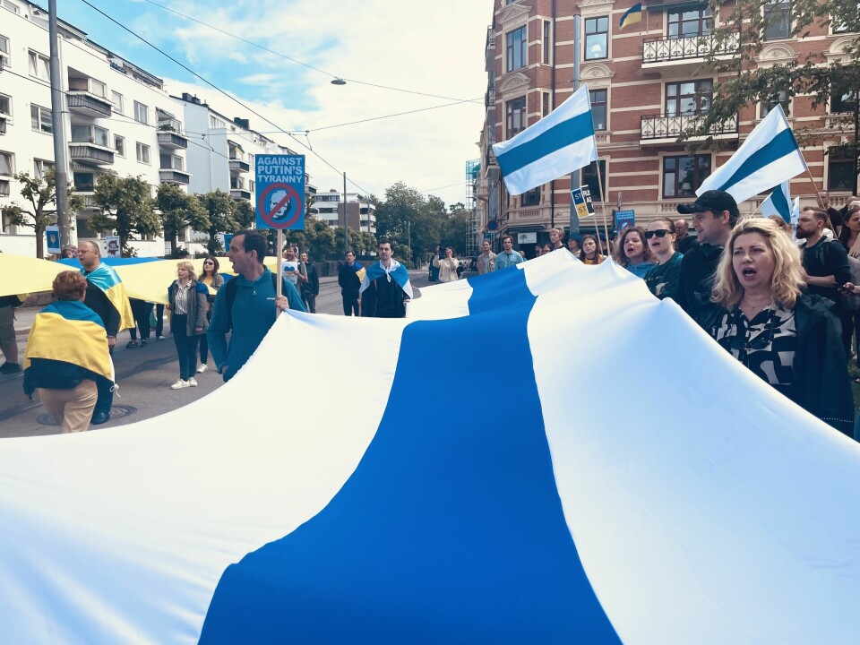 NYTT FLAGG: Russerne samlet seg rundt et russisk flagg hvor den røde fargen er fjernet. Russland demonstrasjon