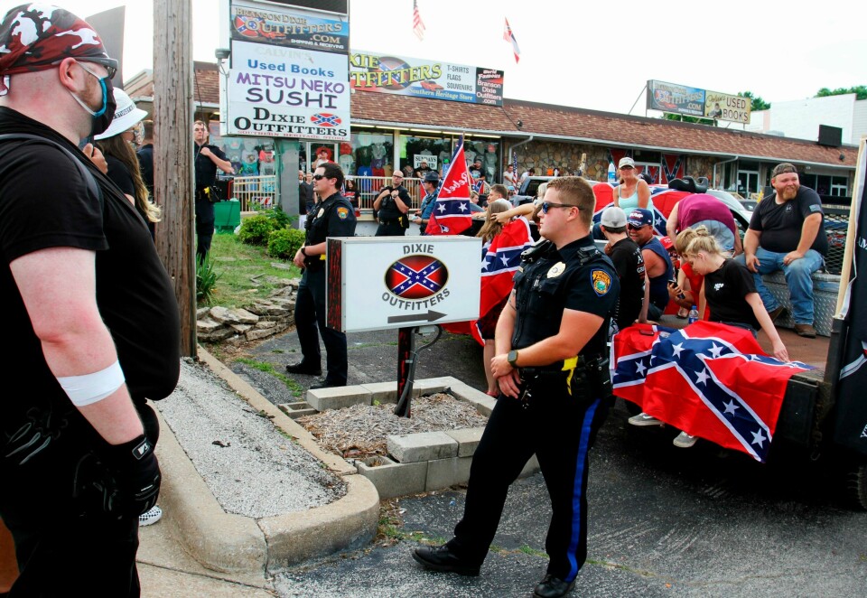 Politiet står mellom hvit-makt-demonstranter og «Black Lives Matter» demonstranter i Branson, Missouri i sommer/illustrasjonsbilde. Police stand between Black Lives Matter protesters and counter-protesters during a demonstration in the parking lot by Dixie Outfitters Sunday, June 21, 2020 in Branson, Mo. Protesters have been gathering outside the strip mall store, which specializes in Confederate flags, clothing and other merchandise. The protests have drawn people from opposing sides of the debate Black Lives Matter demonstrators, as well as those who support the store and the Confederate flag. (Sara Karnes/The Springfield News-Leader via AP)