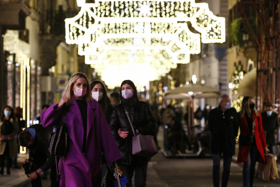 Italiensk jul: Tre damer går i en julepyntet gate i Roma.
