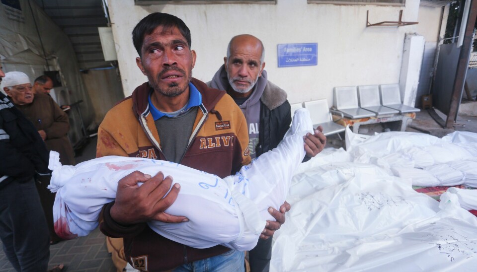 TIRSDAG 12. DESEMBER: En palestiner gjør et barn klar til begravelse i Rafah i Gaza. Siden 7. oktober har over 7.700 barn mistet livet i Gaza, sier det Hamas-kontrollerte helsedepartementet. Palestinere ankommer et likehus i Rafah sør i Gaza med en drept slektning. Foto: Hatem Ali / AP / NTB