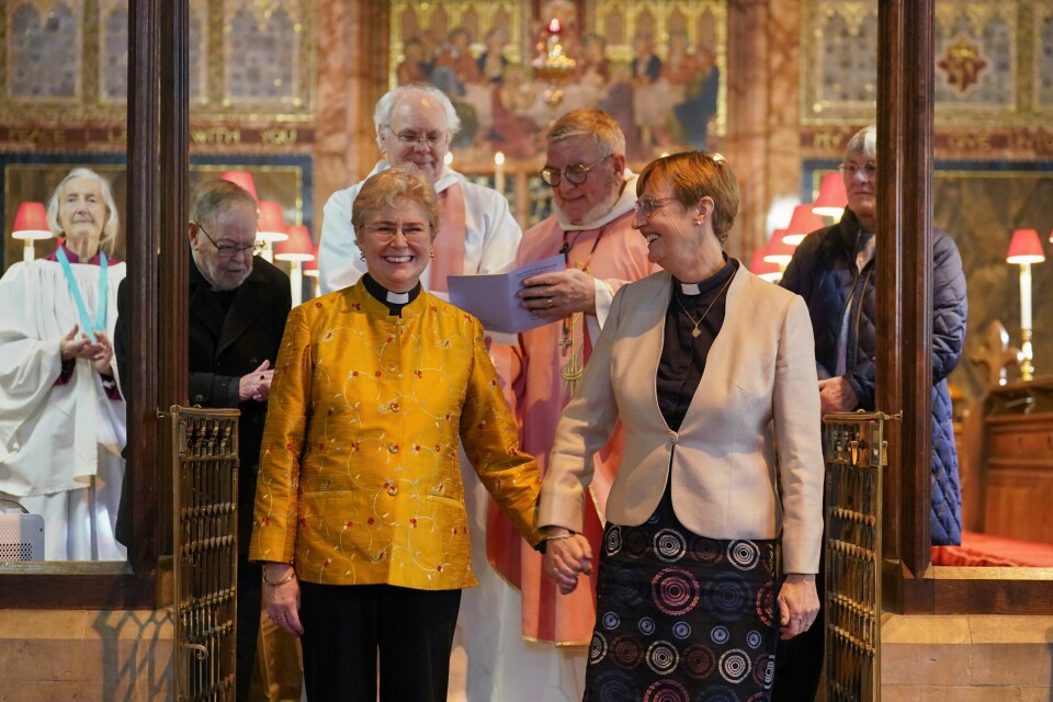 PRESTEPAR: Catherine Bond til venstre og Jane Pearce er begge prester. De er det første likekjønnede paret som ble velsignet i Den engelske kirke. Catherine Bond og Jane Pearce smiler bredt etter å ha blitt velsignet i en gudstjeneste i Felixstowe i England søndag. Foto: Joe Giddens / PA / AP / NTB