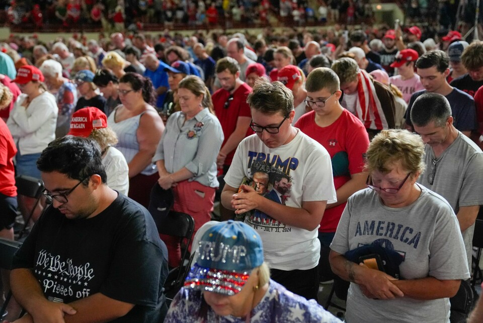 BØYDE HODER: Bønn er et fast rituale før Donald Trumps valgmøter. Supporters standing as they pray before the start of a campaign rally for Republican presidential candidate former President Donald Trump in Harrisburg, Pa., Wednesday, July 31, 2024. (AP Photo/Matt Rourke)