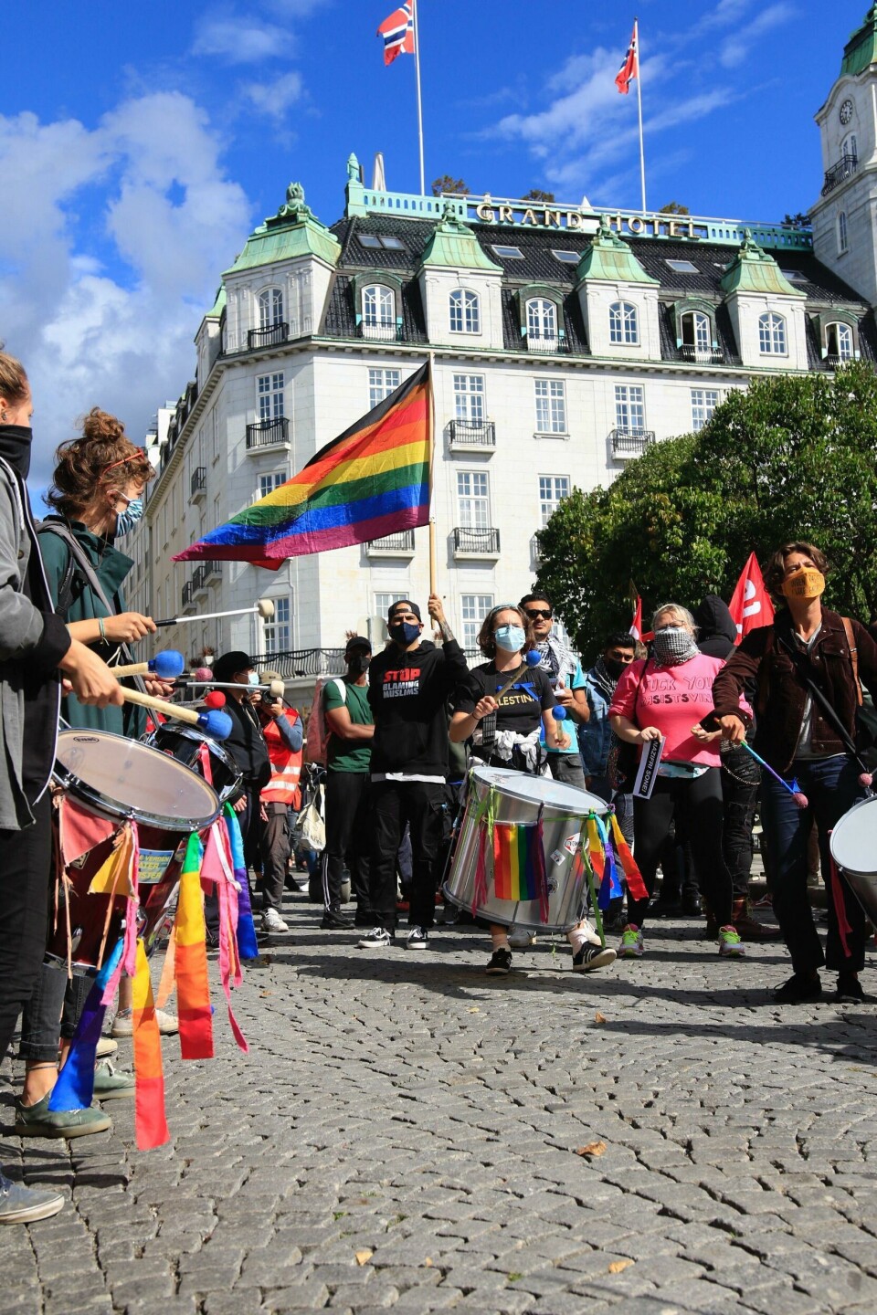 Demonstranter med regnbueflagg og store trommer har møtt opp for å overdøve Sian. Demonstranter med regnbueflagg og store trommer har møtt opp for å overdøve Sian.