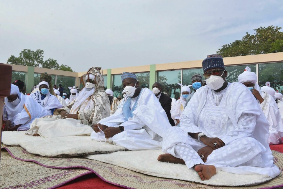 Nigerianske muslimer samlet til bønn under søndagens id-feiring i byen Kano. Alle må bruke munnbind mot koronasmitte. Nigeria Muslims wearing face masks to protect against coronavirus, attend Eid prayers at the Kofar Mata prayer ground in Kano Nigeria, Sunday, May 24, 2020. The holiday of Eid al-Fitr, the end of the fasting month of Ramadan, a usually joyous three-day celebration has been significantly toned down as coronavirus cases soar. (AP Photo)