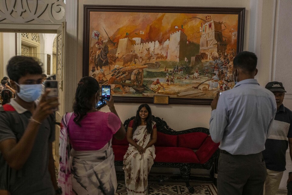 SELFIE: Folk tar selfier foran malerier i presidentpalasset i Colombo etter at palasset ble stormet og president Gotabaya Rajapaksa tvunget til å gå av. Folk tar selfier foran malerier i presidentpalasset i Colombo etter at palasset ble stormet og president Gotabaya Rajapaksa tvunget til å gå av. Foto: Rafiq Maqbool / AP / NTB