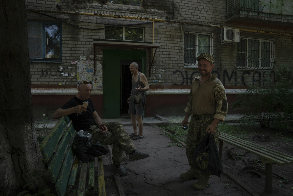 KRAMATORSK: Soldater hviler og tar seg en is foran boligblokka der Valerij Iltsjenko bor. Soldater hviler og tar seg en is foran boligblokka der Valerij Iltsjenko bor. Foto: Nariman El-Mofty / AP / NTB