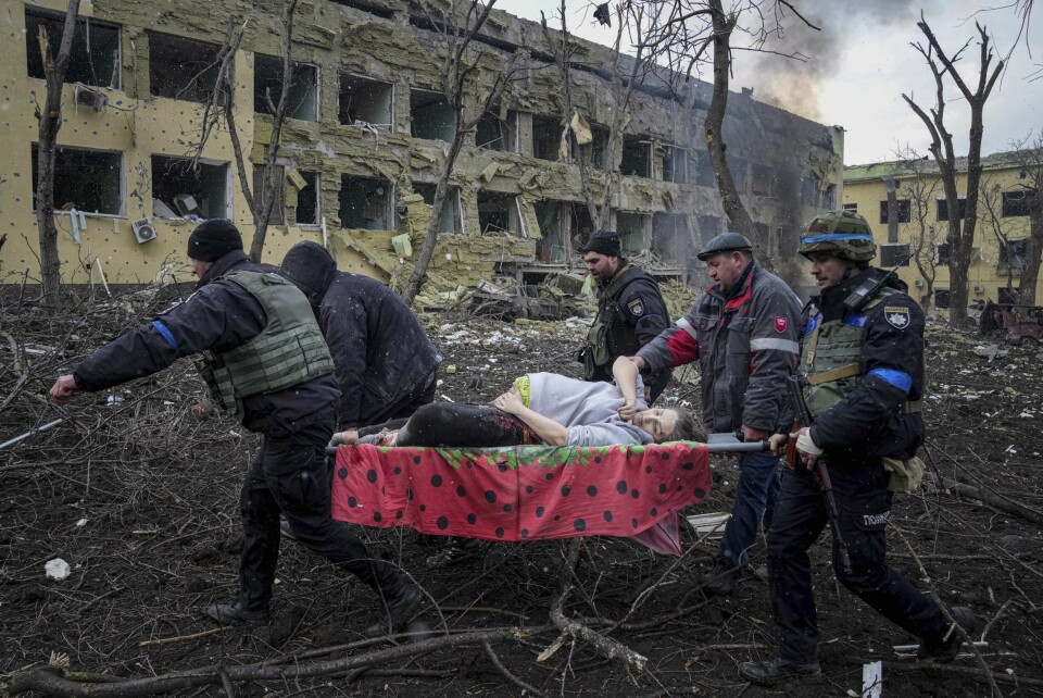 Ukrainsk hjelpepersonell bærer en skadet, gravid kvinne fra en fødeklinikk i Mariupol 9. mars 2022. Både mor og barn døde. En gravid kvinne bæres ut av ruinene på fødeavdelingen til et sykehus i Mariupol etter et russisk angrep mot bygningen. Foto: Jevgenij Maloletka / AP / NTB