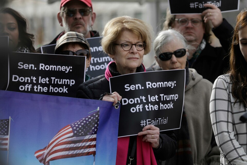 Mange har oppfordret Mitt Romney til å stemme mot sin egen president i riksrettssaken. Onsdag slapp likevel Trump «av kroken». FILE - In this Jan. 16, 2020, file photo, people gather outside the office of Senator Mitt Romney to call on him to push for a full and fair impeachment trial in the Senate with pertinent testimony and evidence during a rally, in Salt Lake City. Republican Sen. Romney is having another big moment as he defies Republican leaders at President Donald Trump's impeachment trial. Romney is one of several GOP senators insisting on hearing from witnesses. (AP Photo/Rick Bowmer, File)