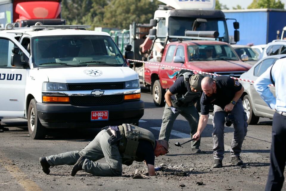 Israelsk politi gransker veien nord for Ashdod der en rakett fra Gazastripen slo ned tirsdag morgen. Israeli police officers examine the site moments after a rocket fired by Palestinians militants from Gaza hit a main free way between Ashdod and Tel Aviv near Ashdod Israel, Tuesday, Nov. 12, 2019. Israel has killed a senior Islamic Jihad commander in Gaza in a rare targeted killing that threatened to unleash a fierce round of cross-border violence with Palestinian militants. (AP Photo/Ariel Schalit)