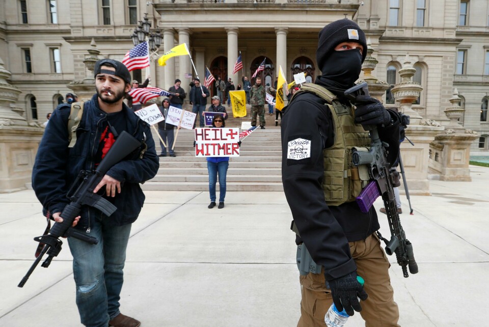 I april dukket det opp mange bevæpnede demonstranter til Michigans kongressbygning. De protesterte mot strenge koronatiltak og ba blant annet om å få lov til å gå tilbake på jobb. President Donald Trump heiet dem fram ved å tvitre 'Frigjør Michigan'. (AP Photo/Paul Sancya, File) FILE - In this April 15, 2020, file photo, protesters carry rifles near the steps of the Michigan State Capitol building in Lansing, Mich. Many African Americans watching protests calling for easing restrictions meant to slow the spread of the new coronavirus see them as one more example of how their health and their rights just dont seem to matter. (AP Photo/Paul Sancya, File)