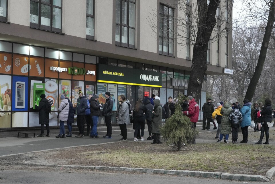 PENGER: Folk i kø for at ta ut penger fra minibanker. Mange var tomme. Køene var lange foran minibanker og vekslingskontorer i Kyiv torsdag. Foto: AP / NTB