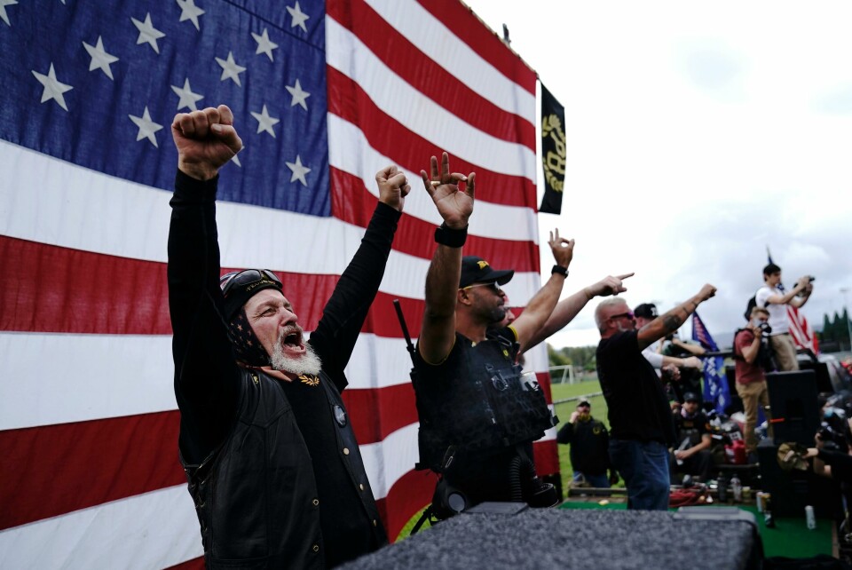 President Donald Trumps kommentar om Proud Boys (bildet) under TV-debatten mot Joe Biden, der han oppfordret den høyreekstreme hvite nasjonalistgruppen til å være i beredskap, skapte sterke reaksjoner. FILE - In this Sept. 26, 2020 file photo, members of the Proud Boys, including leader Enrique Tarrio, second from left, gesture and cheer on stage as they and other right-wing demonstrators rally in Portland, Ore. President Donald Trump didn't condemn white supremacist groups and their role in violence in some American cities this summer. Instead, he said the violence is a left-wing' problem and he told one far-right extremist group to stand back and stand by. His comments Tuesday night were in response to debate moderator Chris Wallace asking if he would condemn white supremacists and militia groups. Trump's exchange with Democrat Joe Biden left the extremist group Proud Boys celebrating what some of its members saw as tacit approval. (AP Photo/John Locher)