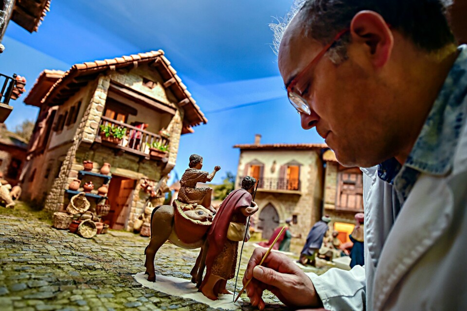 Detaljer finpusses på en julekrybbe som stilles ut i Pamplona, i Nord-Spania. Kunstneren er medlem av en gruppe som går sammen om å lage julescenene i krybbene som kalles Belenes (Betlehem). In this photo taken on Friday Nov. 30, 2018, a member of a nativity scene making group, adds the final touches to a nativity scene, known in Spain as ''Belenes'', in Pamplona, northern Spain. Spain celebrates the Christmas season with ancient Catholic traditions including the 'Belenes', which are handmade from polystyrene and decorated with small nativity figures. (AP Photo/Alvaro Barrientos)