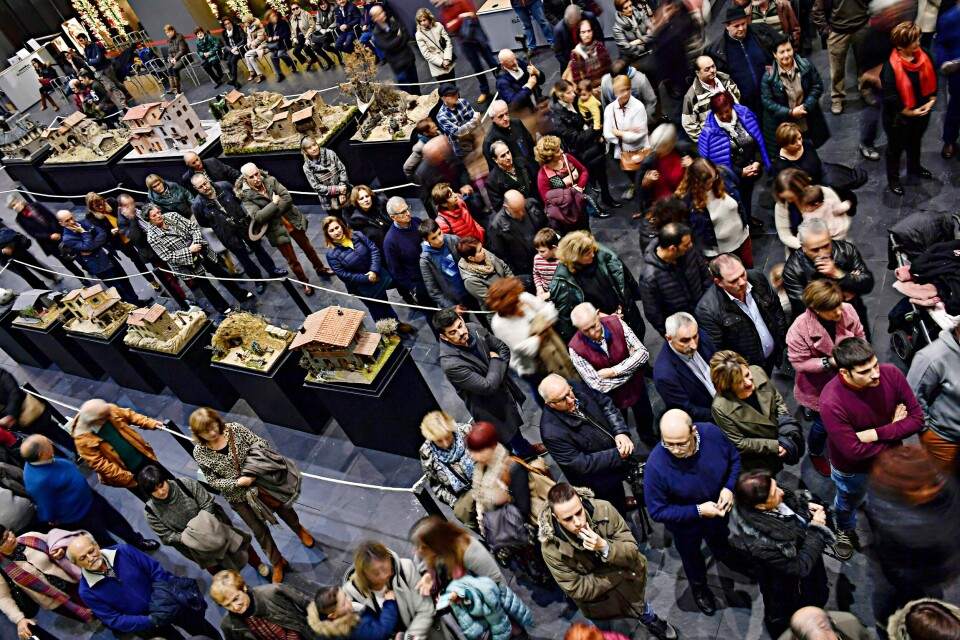 Folk står i kø for å se på julekrybbene, som har en lang tradisjon i katolske Spania. In this photo taken on Sunday, Dec. 2, 2018, visitors look at the nativity scenes, known in Spain as ''Belenes'', in Pamplona, northern Spain. Spain celebrates the Christmas season with ancient Catholic traditions including the 'Belenes', which are handmade from polystyrene and decorated with small nativity figures. (AP Photo/Alvaro Barrientos)