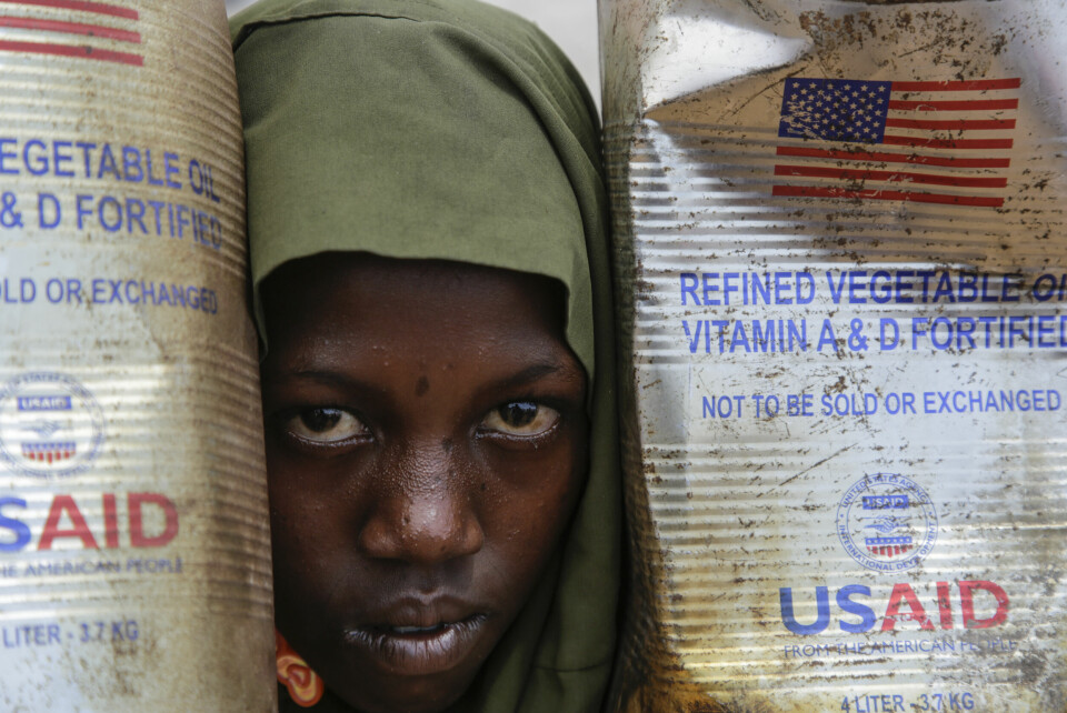 SOMALIA: Et internt fordrevet barn kikker ut mellom kanner med matolje sendt av USAID til Maslah-leiren utenfor Mogadishu i Somalia i februar. Et internt fordrevet barn kikker ut mellom kanner med matolje sendt av USAID til Maslah-leiren utenfor Mogadishu i Somalia i februar. Foto: Farah Abdi Warsameh / AP / NTB