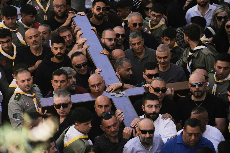 LANGFREDAG: Pilegrimer bar kors gjennom gamlebyen i Jerusalem langfredag. Mange av pilegrimene som gikk i Jesu fotspor gjennom Jerusalem, bar kors, slik Jesus gjorde på vei til korsfestelsen. Foto: Mahmoud Illean / AP / NTB