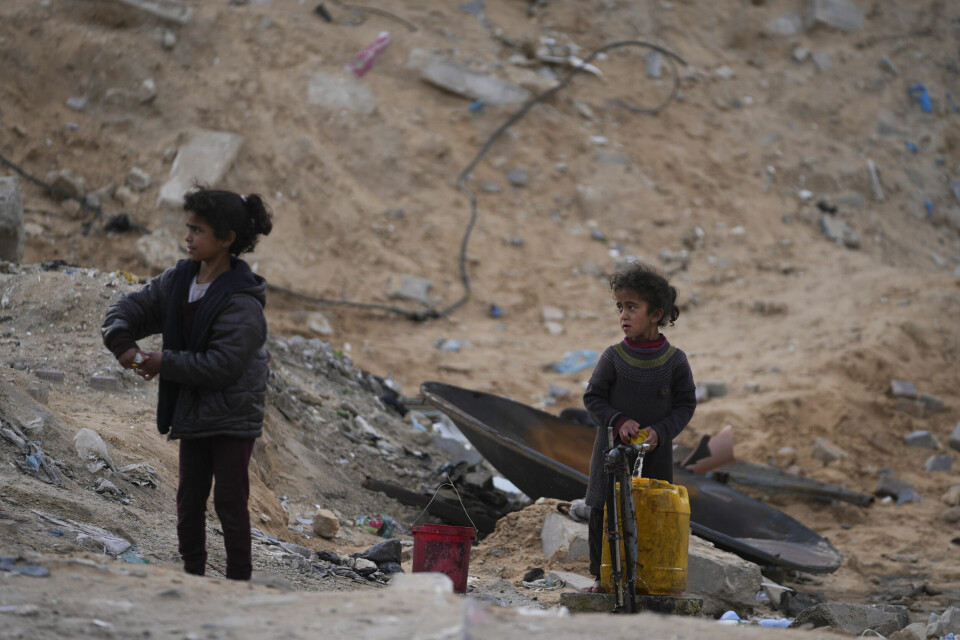 To palestinske jenter fyller en plastkanne med rent vann på en FN-drevet skole i Gaza by, der de nå bor. Bildet ble tatt søndag. Foto: Jehad Alshrafi / AP / NTB To palestinske jenter fyller en plastkanne med rent vann på en FN-drevet skole i Gaza by, der de nå bor. Bildet ble tatt søndag. Foto: Jehad Alshrafi / AP / NTB