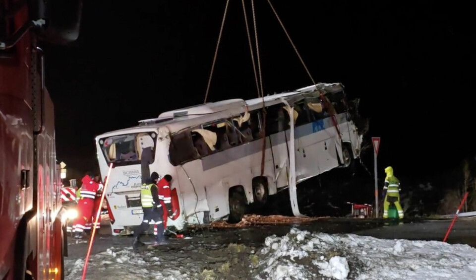 Bussen ble løftet opp av vannet natt til fredag. Bildet viser en stor kranbil som løfter opp bussen som hadde kjørt av veien. Foto: Jens Andre M. Birkeland / NTB